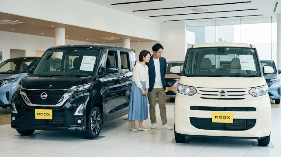 日産のショールームで、ルークス ハイウェイスター（ブラック）と標準モデル（アイボリー）を並べてデザインを比較する日本人夫婦。